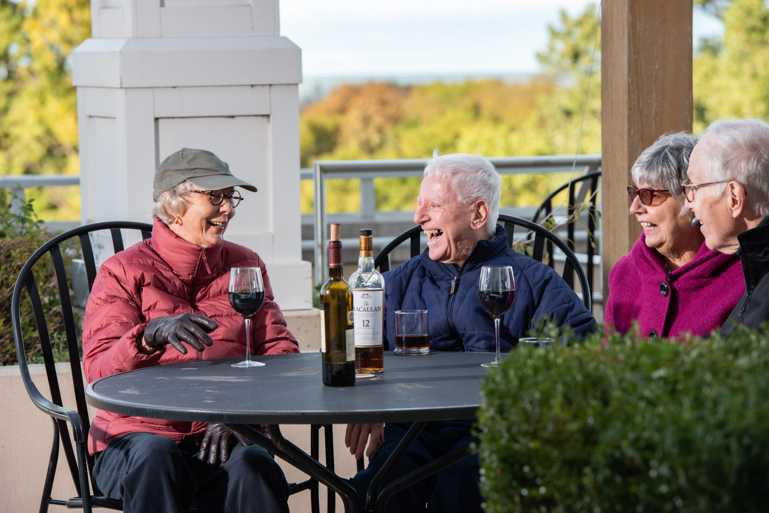 group of seniors sitting outside having a glass of wine